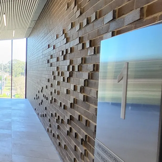 A textured brick feature wall in a building lobby